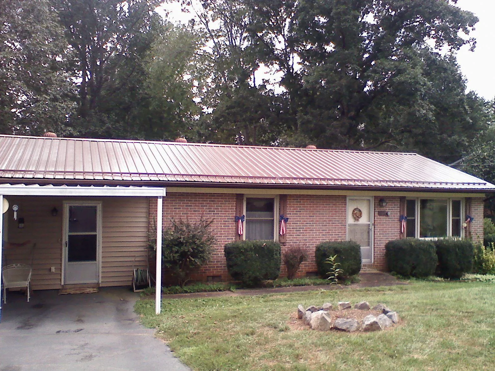 Bronze metal roof and carport on a brick ranch home — Roof Repair work by our crew in Midvale